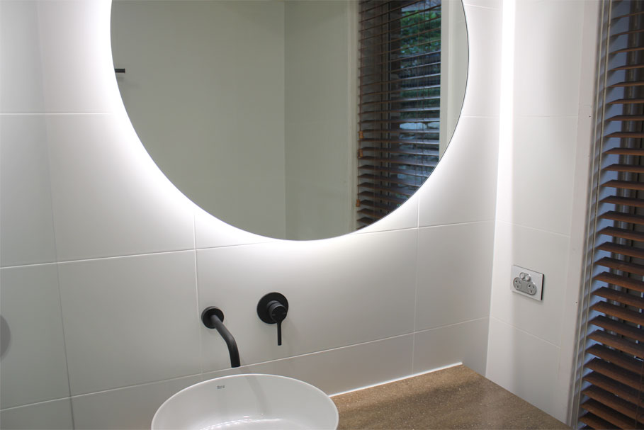 Round Halo Bathroom Lighted Mirror hanging above single sink