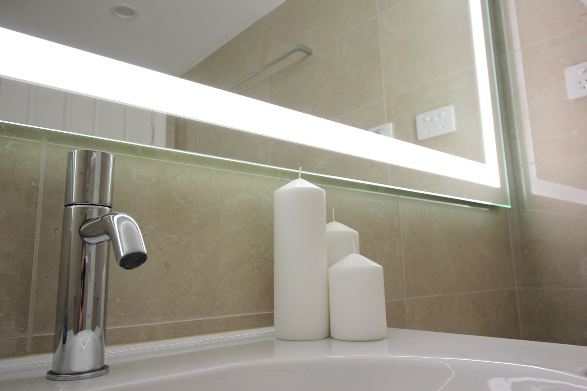 Bottom corner of a mirror with lights in a Sydney apartment